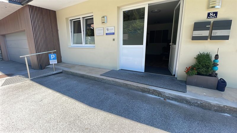 Ebenerdiger Eingang der Praxis mit Parkplatz
